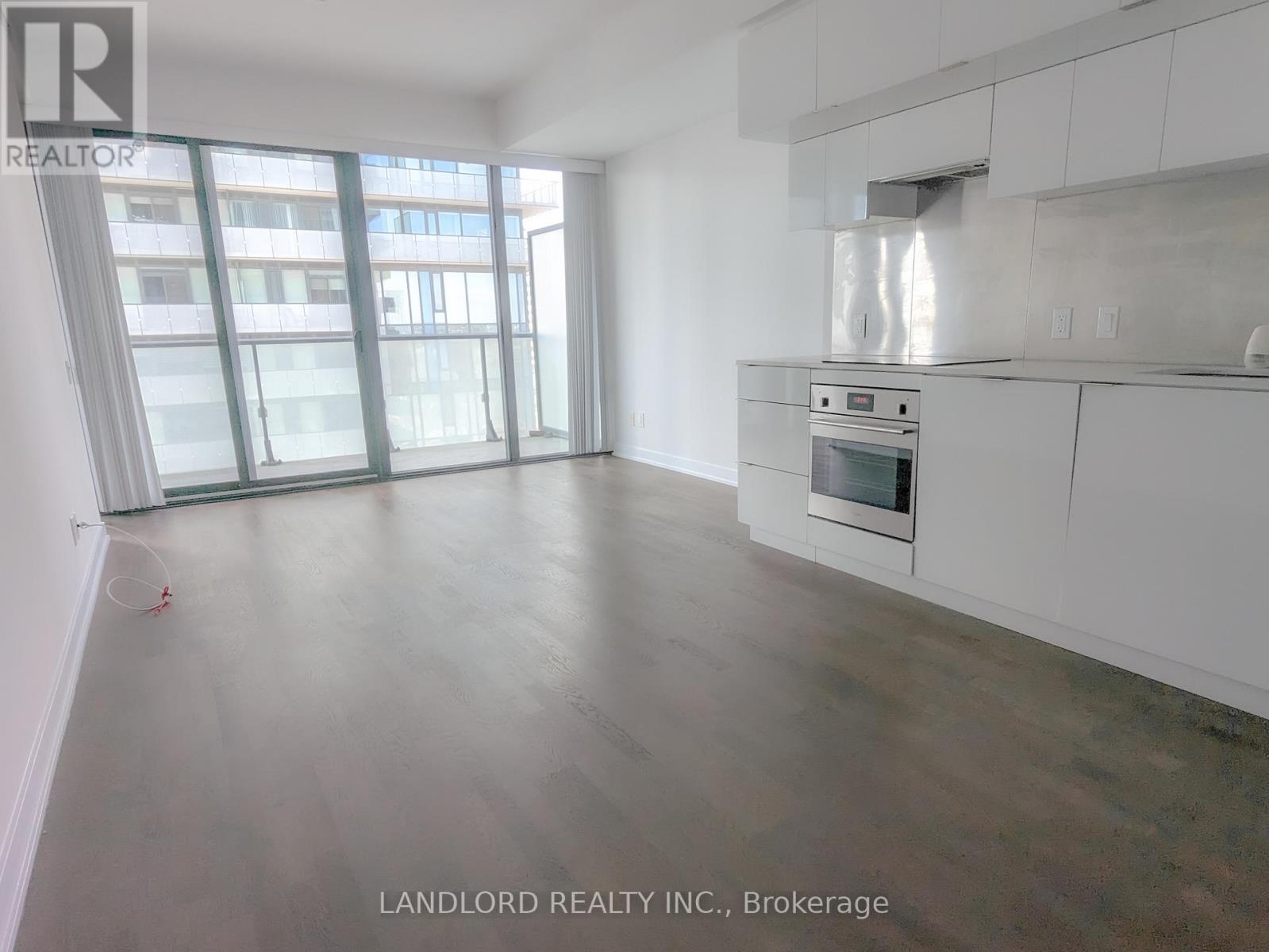 A spacious kitchen with white cabinets and a stainless steel oven.