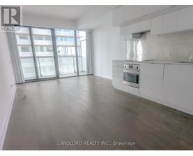 A spacious kitchen with white cabinets and a stainless steel oven.