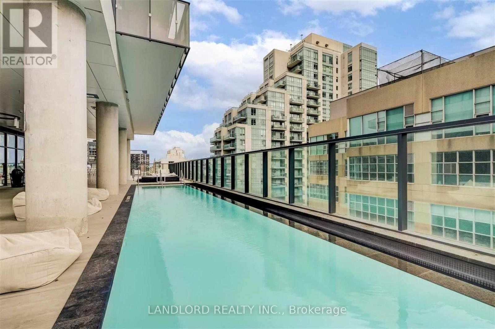 A pool on a balcony with a view of buildings.