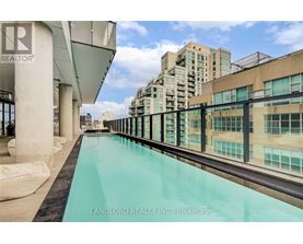 A pool on a balcony with a view of buildings.