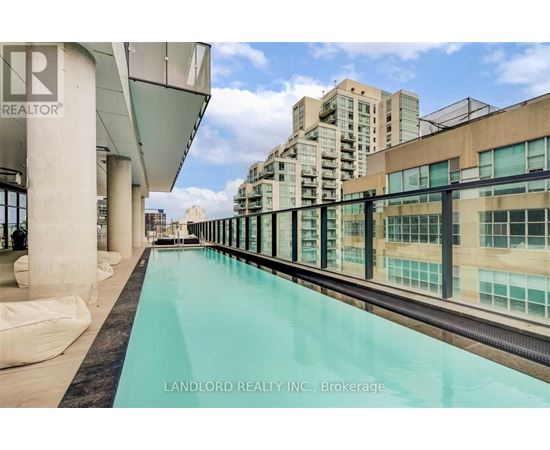 A pool on a balcony with a view of buildings.