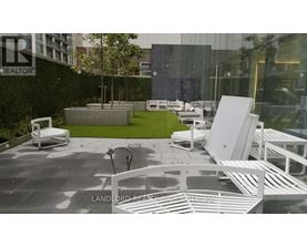 A white outdoor furniture set is displayed in front of a glass building.
