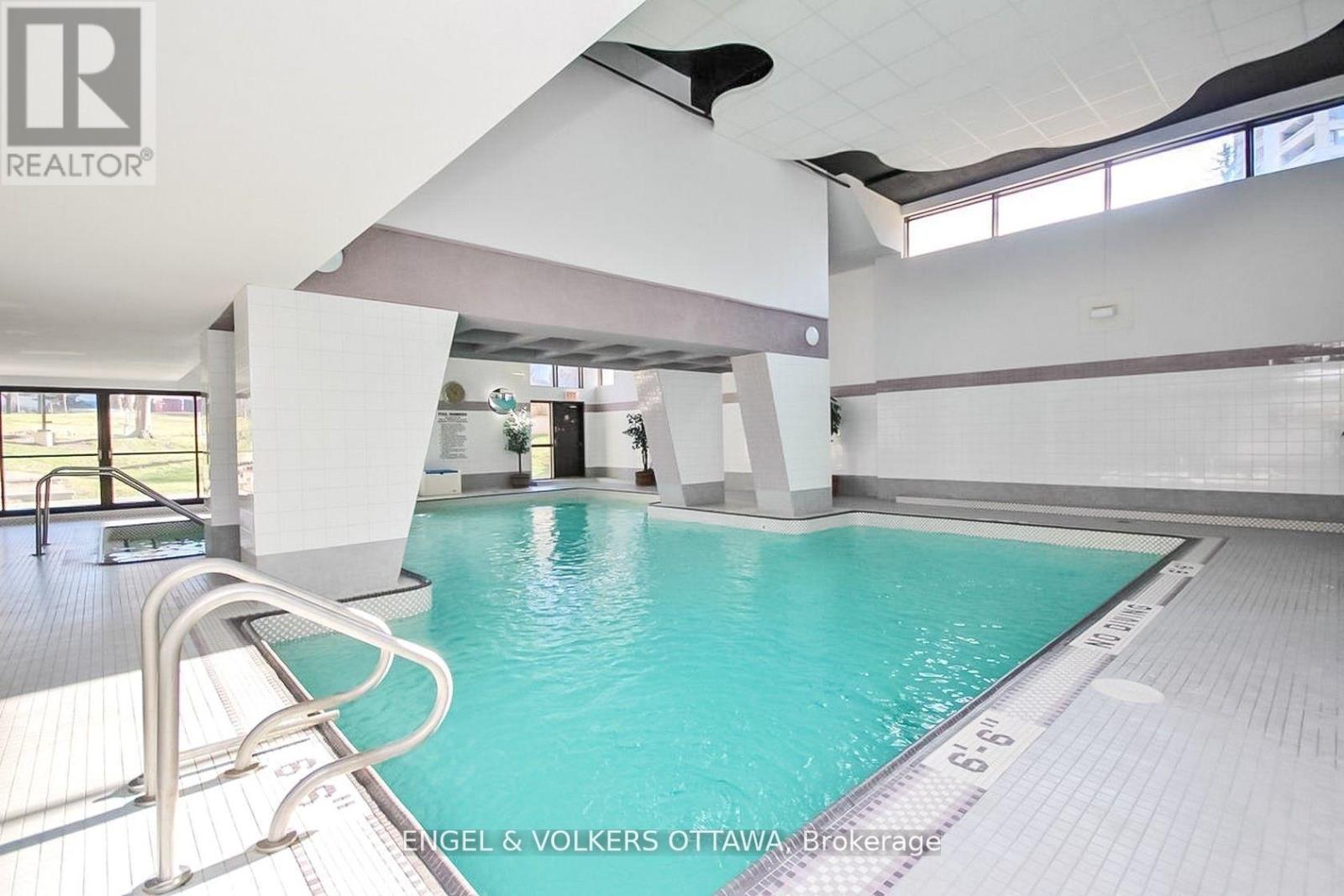 A large indoor swimming pool with a ladder on the left side.