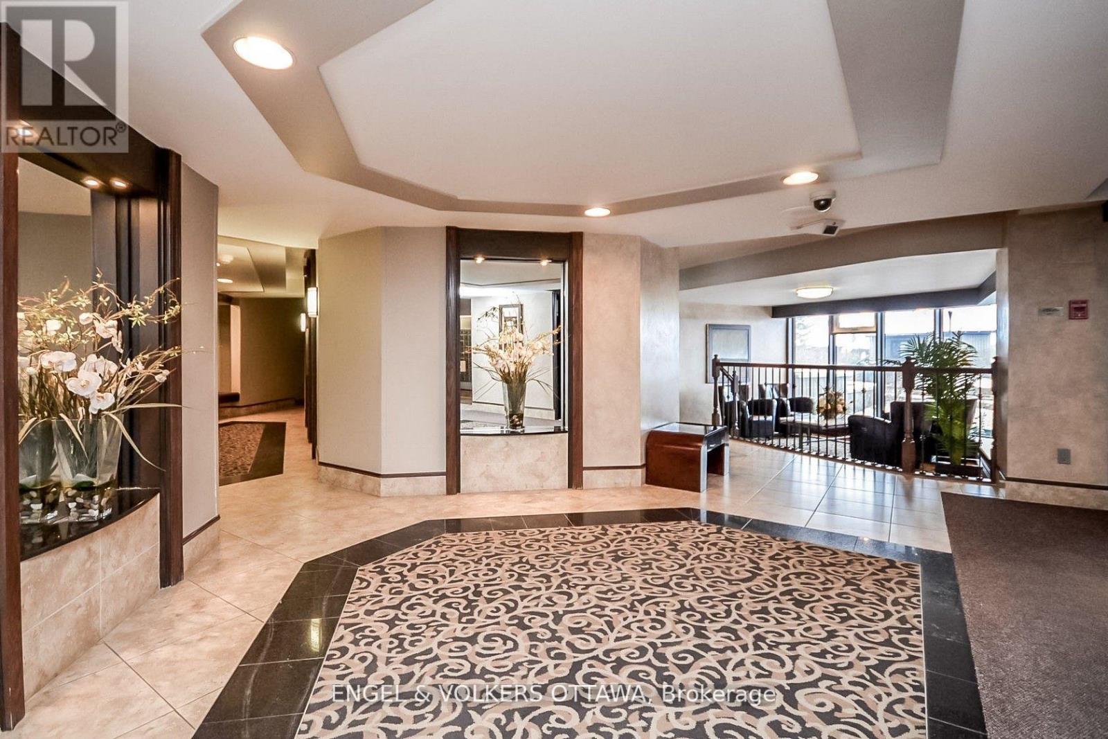 A spacious lobby with a marble floor and a chandelier.