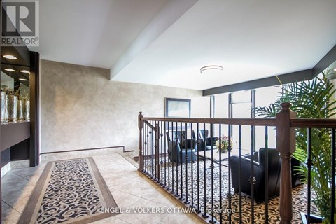 A living room with a black couch and a patterned rug.