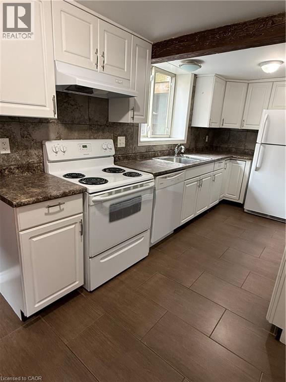A kitchen with white appliances and cabinets.