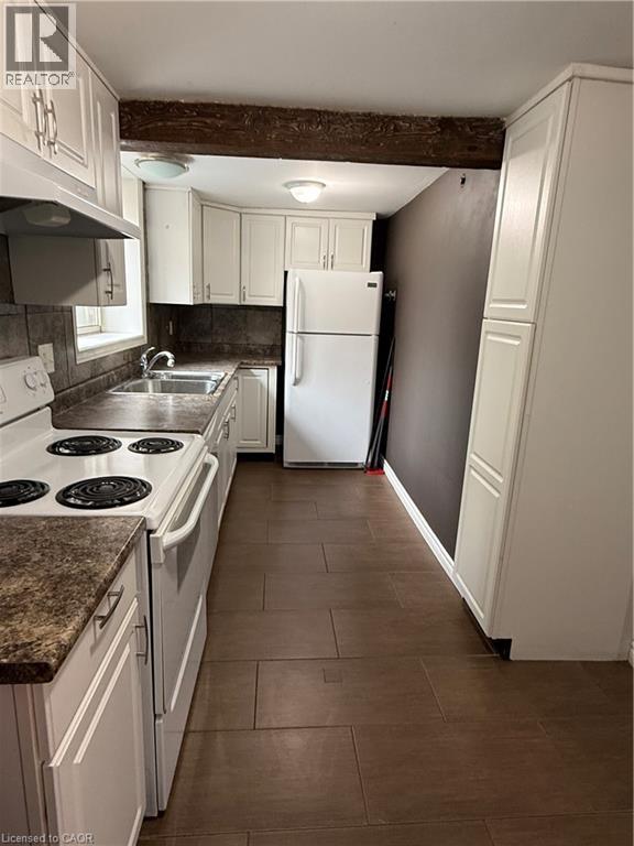A kitchen with white cabinets and a white refrigerator.