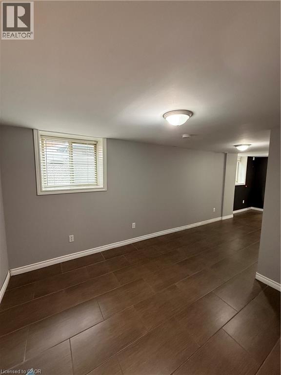 A room with wooden flooring and a window with blinds.