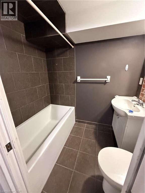 A small bathroom with a toilet, sink and bathtub.