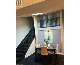 A dining room with a table and chairs and a staircase.