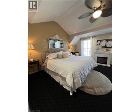 A bedroom with a large bed and a fireplace.