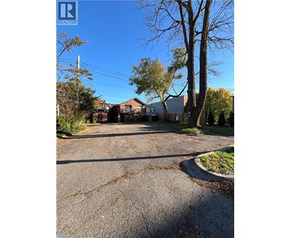 A street view with houses and trees on a sunny day.