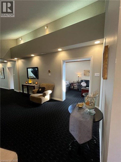A living room with a grey carpet and a grey couch.