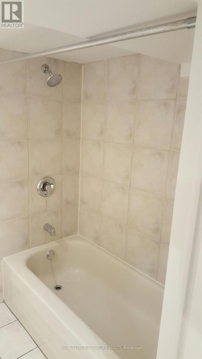A white bathtub with a shower head and faucet.