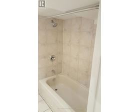A white bathtub with a shower head and faucet.