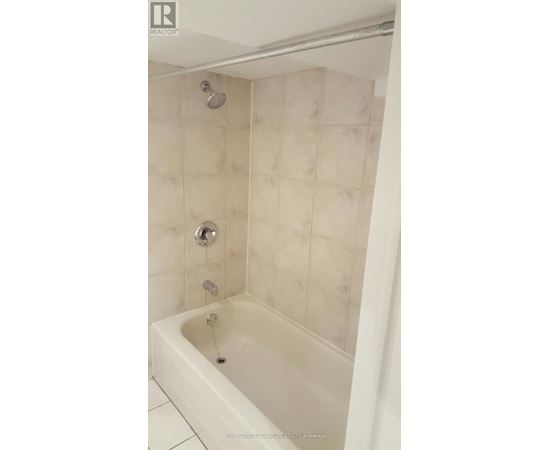 A white bathtub with a shower head and faucet.
