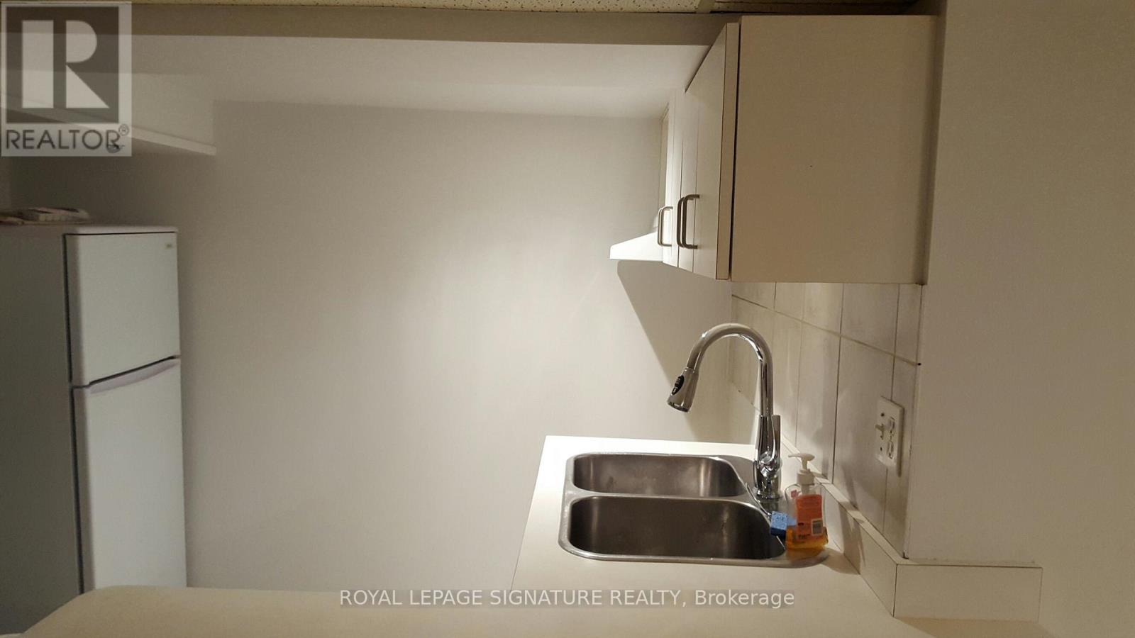 A kitchen with a sink and a refrigerator.
