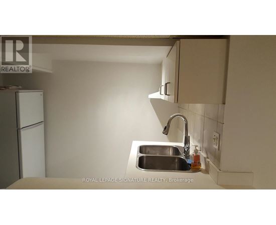 A kitchen with a sink and a refrigerator.