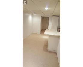 A white room with a desk and a cabinet.