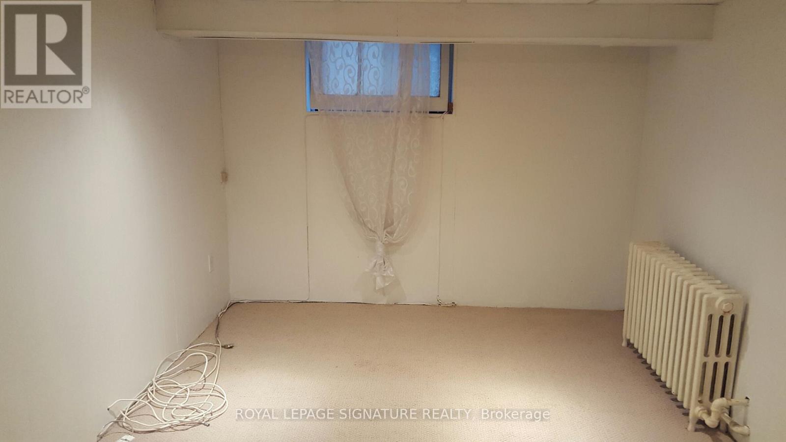 A white room with a window and a radiator.