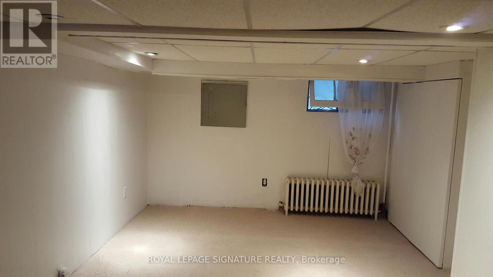 A room with a window and a radiator on the floor.