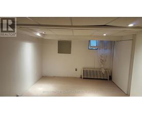A room with a window and a radiator on the floor.