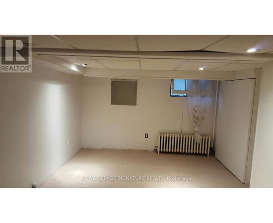 A room with a window and a radiator on the floor.