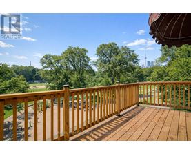 A wooden deck with a view of a park and a city skyline.