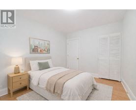 A bedroom with a bed, nightstand, and a painting on the wall.