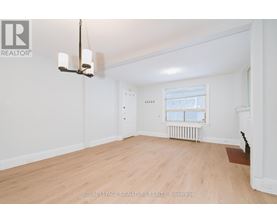 A well-lit, empty room with a window and radiator.