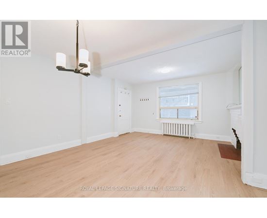 A well-lit, empty room with a window and radiator.