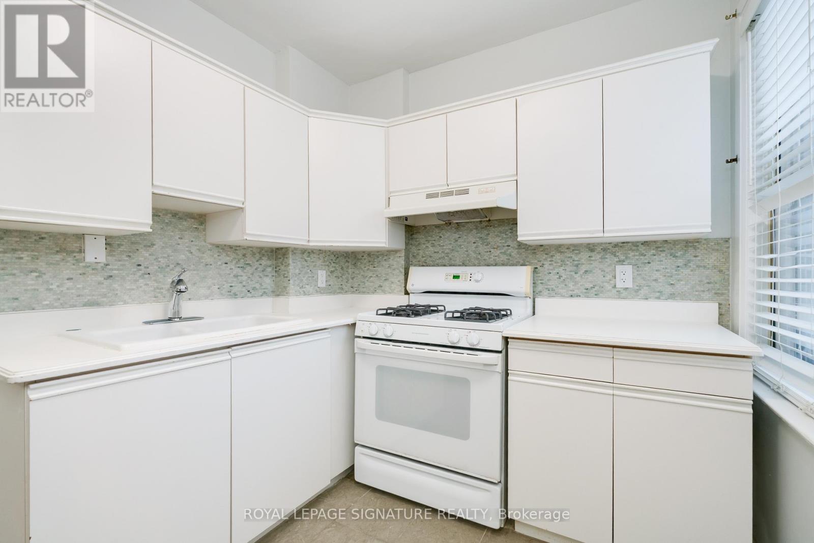 A white kitchen with a stove and cabinets.