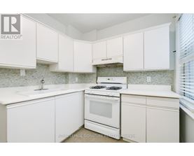 A white kitchen with a stove and cabinets.