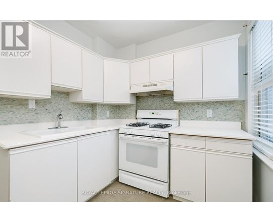 A white kitchen with a stove and cabinets.