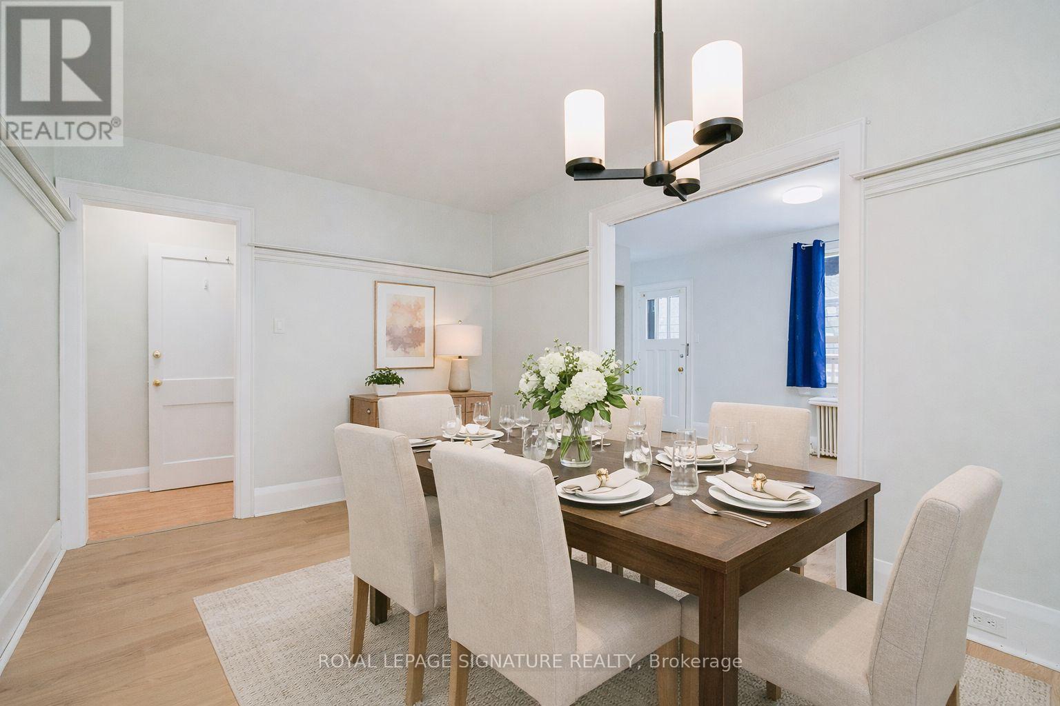 A dining room with a wooden table set for six.