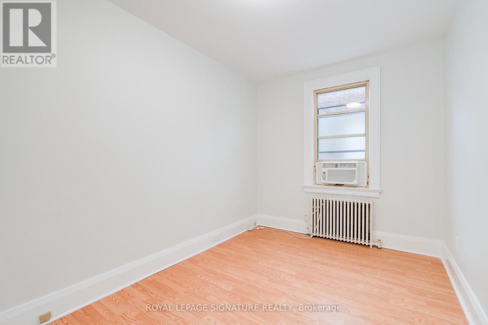 A white room with a window and a radiator.