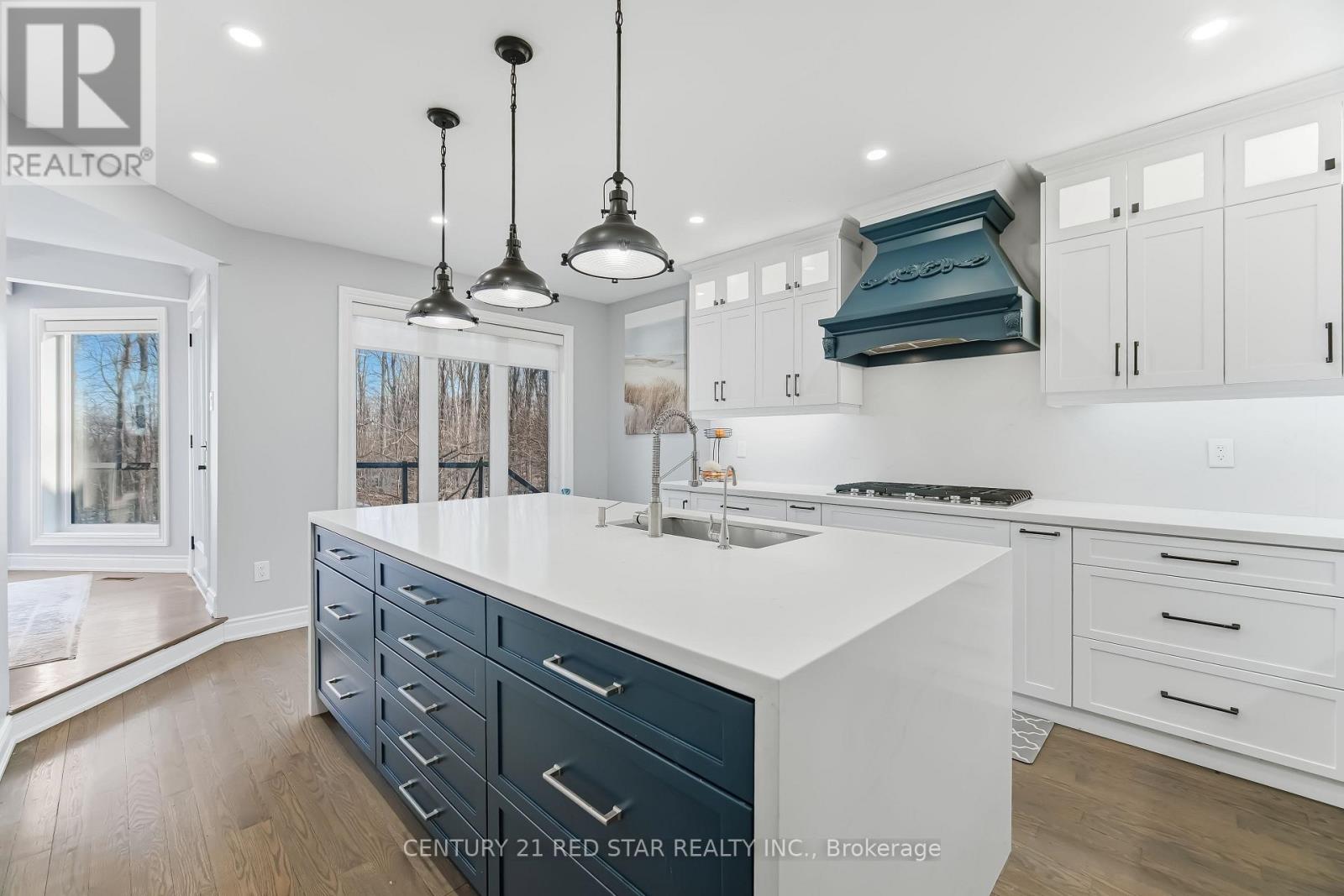 A kitchen with white countertops and dark blue cabinets.