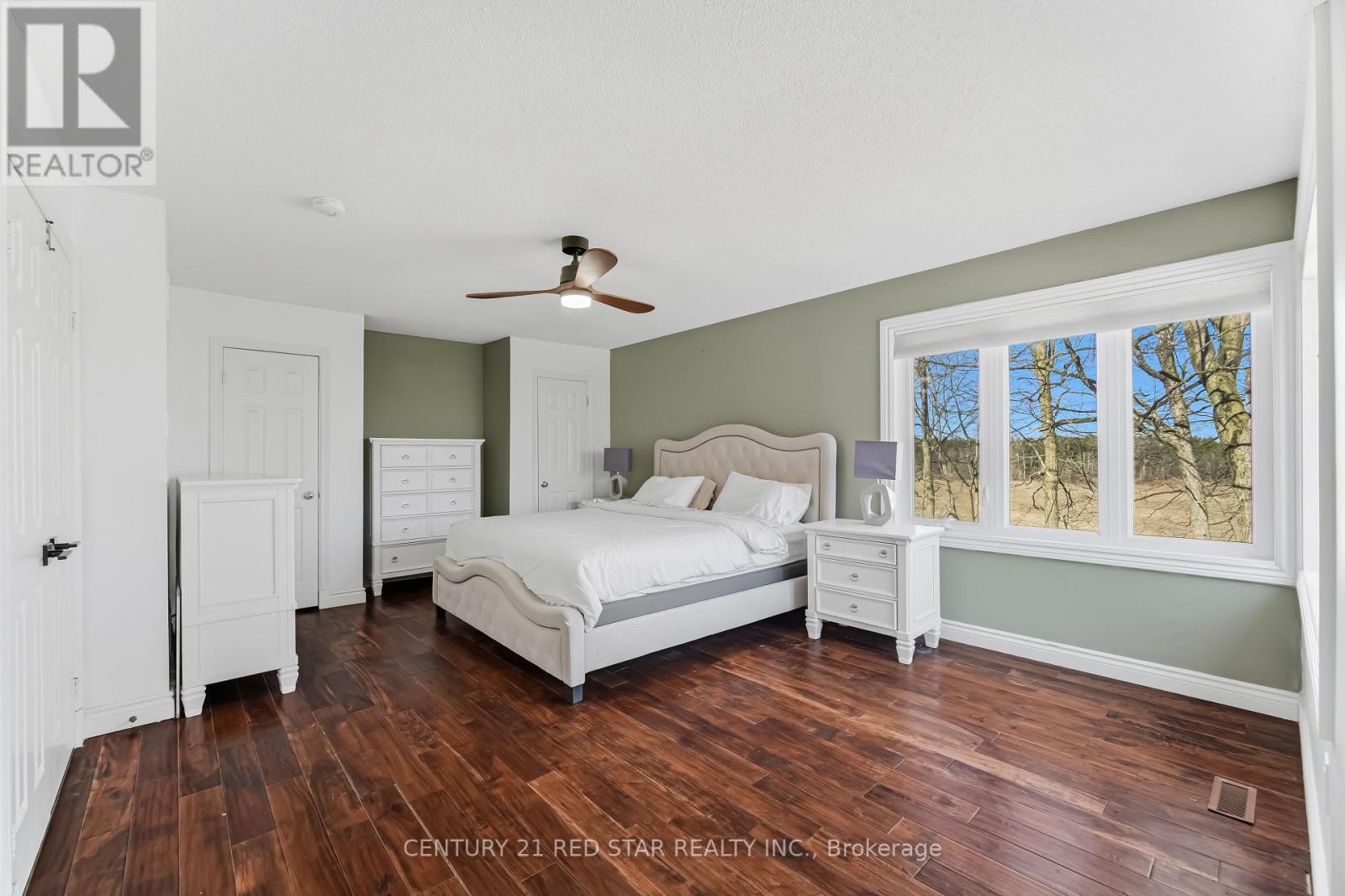A bedroom with a bed, dresser, and nightstand.