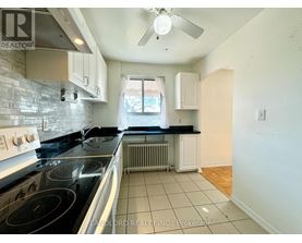 A kitchen with a black stove top oven and white cabinets.