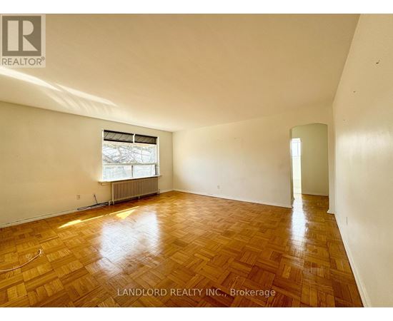 A room with wooden flooring and a window with blinds.