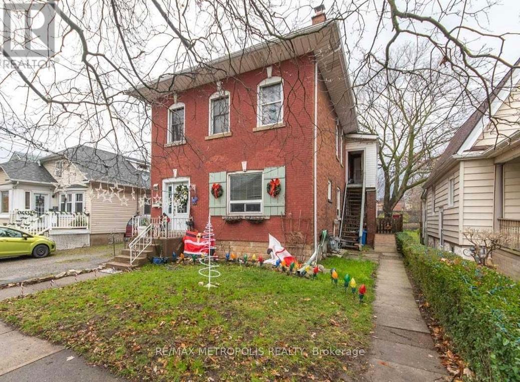 A red brick house with a green lawn in front.
