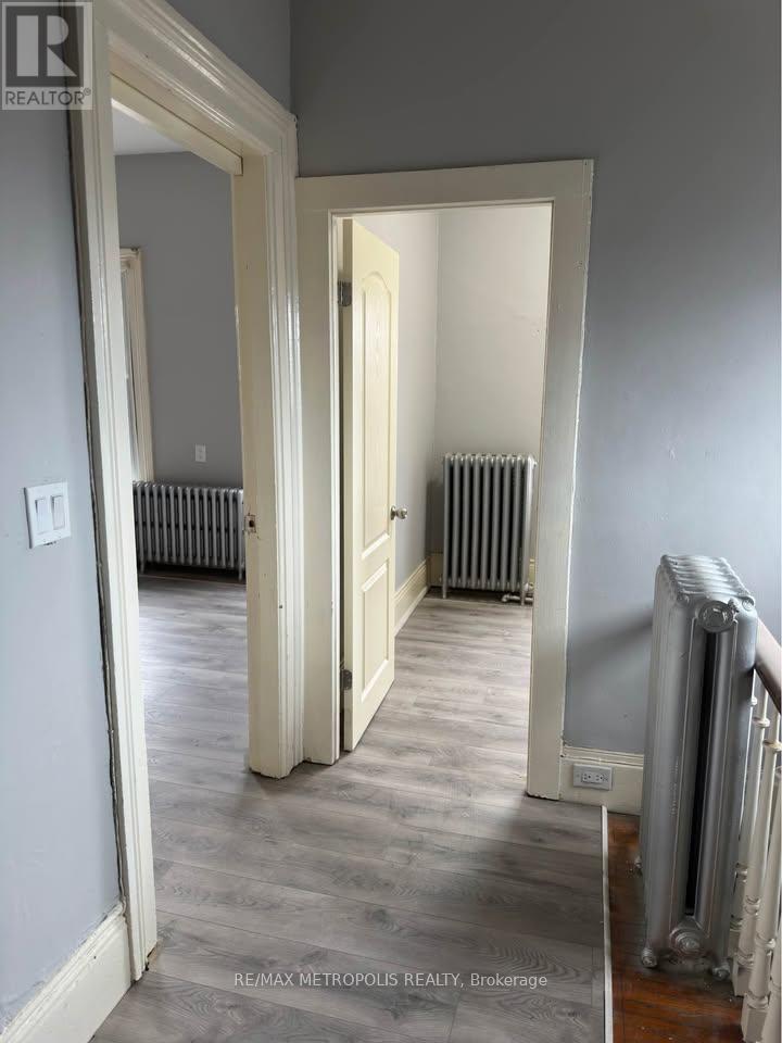 A hallway with a white door and a radiator on the wall.