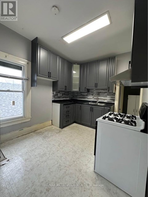 A kitchen with a white stove top oven and a window.