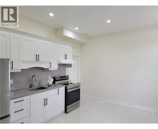 A kitchen with white cabinets and appliances.