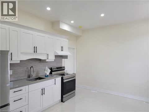A kitchen with white cabinets and appliances.