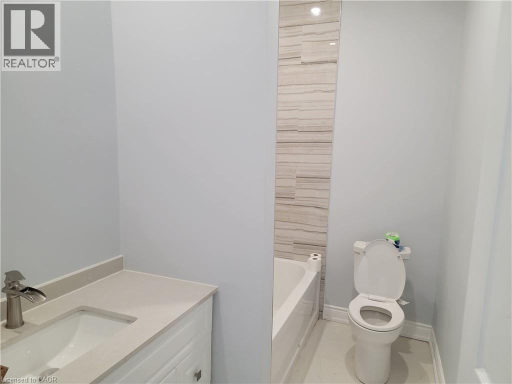 A white toilet in a bathroom with a white sink.