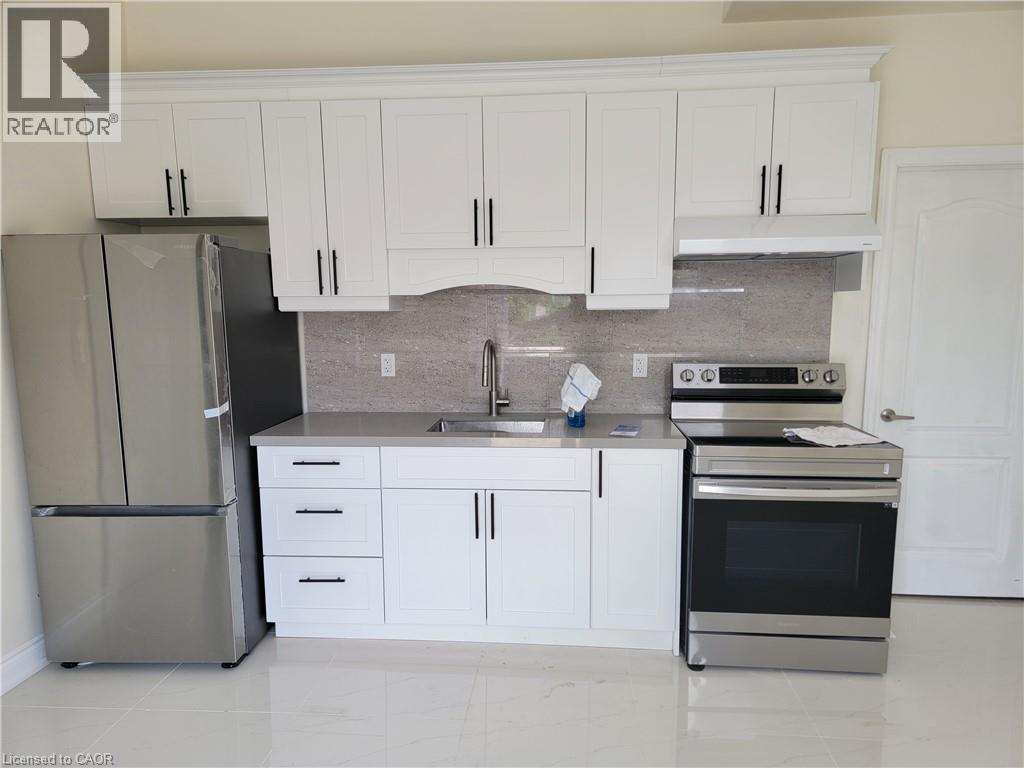 A kitchen with white cabinets and a stainless steel refrigerator.