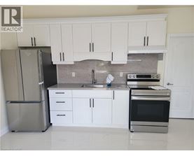 A kitchen with white cabinets and a stainless steel refrigerator.