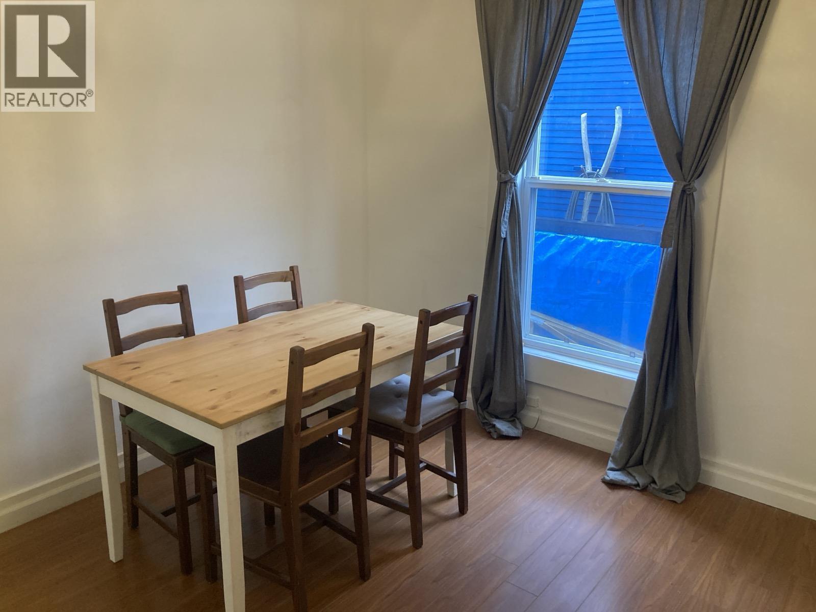 A dining room with a table and chairs.