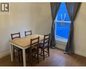 A dining room with a table and chairs.